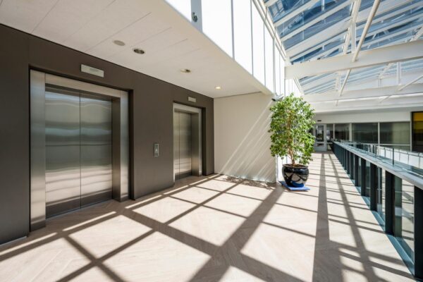 Heldere, moderne bedrijfsruimte aan de Thomas R. Malthusstraat met twee liften en een glazen dak dat veel daglicht binnenlaat.